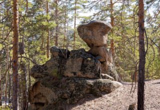 Скала Окжетпес с нижнего ракурса, причудливые скалы и камни вокруг.