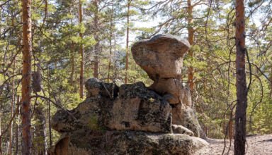 Скала Окжетпес с нижнего ракурса, причудливые скалы и камни вокруг.