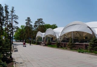 Старинные дома, новые отели и строящиеся кафе, улицы, немного ожидающих лето людей, озеро, лодочная станция, центральная площадь, памятник Героям. 26 мая 2023.