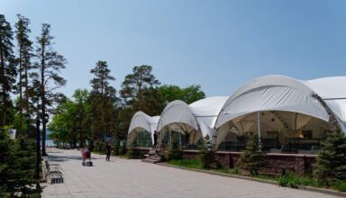 Старинные дома, новые отели и строящиеся кафе, улицы, немного ожидающих лето людей, озеро, лодочная станция, центральная площадь, памятник Героям. 26 мая 2023.